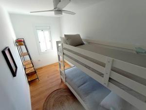 ein Schlafzimmer mit einem Etagenbett mit einer Leiter. in der Unterkunft Ático cerca Playa y centro a 10 min. in Barcelona