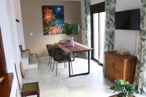 a dining room with a table and chairs and a painting at Tropical Old Town Marbella in Marbella
