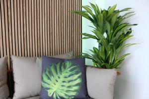 馬貝拉的住宿－Tropical Old Town Marbella，沙发上一组枕头,有两只植物