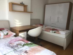 1 dormitorio con 2 camas, escritorio y silla en Apartmán v centre, 4os., parking, en Bratislava