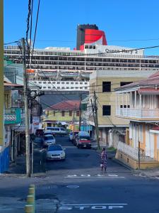 a city street with a cruise ship in the background at La Caille Créole in Roseau