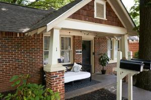 a porch of a brick house with a bed in it at Cozy Atl Getaway - 5 Min From Airport & Downtown in Atlanta