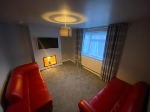 a living room with a red couch and a window at House near city centre in Leicester