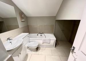 a bathroom with a toilet and a tub and a sink at Union Terrace Garden View in Aberdeen