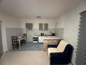 uma cozinha com um sofá e uma mesa num quarto em Apartman DALT em Trebinje