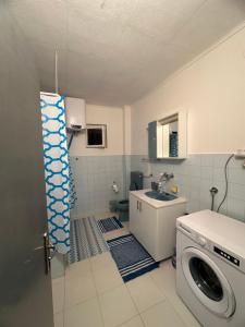 uma pequena casa de banho com uma máquina de lavar roupa e um lavatório em Apartman DALT em Trebinje
