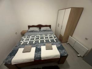 a bedroom with two beds and a cabinet at Apartman DALT in Trebinje