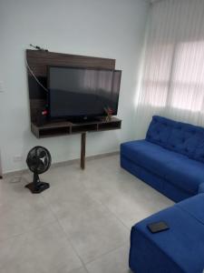Uma televisão e/ou sistema de entretenimento em Aluguel Casa Diária Guarujá Ótima Localização com Garagem