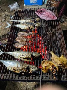 un montón de pescado cocinando en una parrilla en Lanta natural hut garden, en Phra Ae beach