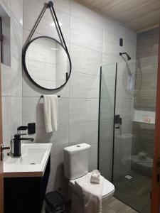 a bathroom with a shower and a toilet and a sink at Pousada Ponta da Vigia in Penha