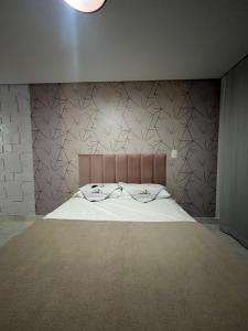 a bedroom with a bed with a brown headboard at Makambira 307 in Porto De Galinhas