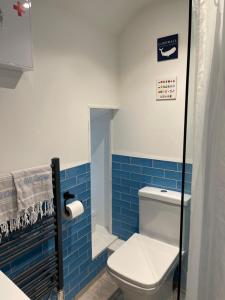 a bathroom with a toilet and blue tiles at Cobble Cottage in St Just