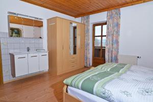 1 dormitorio con 1 cama y cocina con fregadero en Ferienwohnung Josef Müller, en Arnbruck