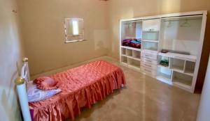 Schlafzimmer mit einem Bett mit einer roten Tagesdecke in der Unterkunft Chácara Moreira in Tianguá