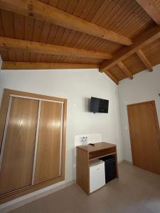 Habitación con armario y TV en la pared. en Quinta da Boavista en Vila Nova de Milfontes