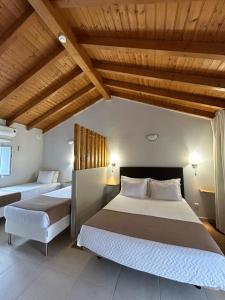 a bedroom with two beds and a wooden ceiling at Quinta da Boavista in Vila Nova de Milfontes