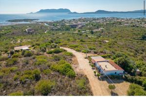 an aerial view of a house on a hill next to the ocean at Bellavista Vacation stunning Tavolara sea view terrace in Olbia +41 photos