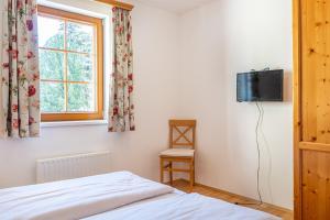 a bedroom with a bed and a tv on a wall at Stranach Appartements in Sankt Michael im Lungau