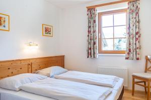 2 camas num quarto com uma janela em Stranach Appartements em Sankt Michael im Lungau