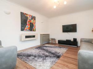 a living room with a couch and a tv at Summerhayes in Redruth