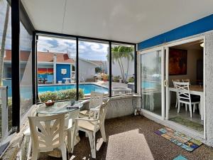 a balcony with a table and chairs and a pool at Madeira Beach Yacht Club 323b in St. Pete Beach
