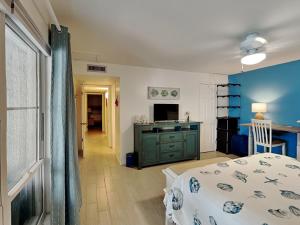 a bedroom with a bed and a desk and a television at Madeira Beach Yacht Club 323b in St. Pete Beach