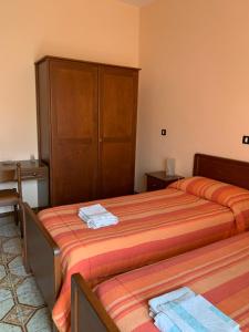 ein Hotelzimmer mit 2 Betten und einem Schrank in der Unterkunft Hotel Villa Carla in Piana Crixia