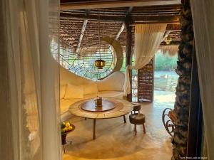 - un salon avec une table et une fenêtre dans l'établissement Bakuba Lodge - Le petit hôtel du Voyageur, à Ankilibe
