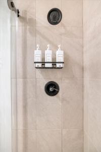 a shower with three soap bottles on a wall at Beautiful home with spa and golf in Las Vegas