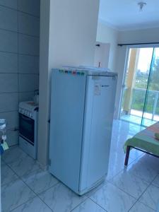 a small refrigerator in a kitchen with a stove at Pousada dos Reis in Barra de Ibiraquera