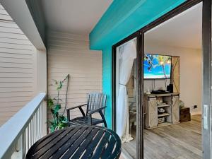 uma varanda com uma cadeira e uma televisão em Villa Del Sol 1145 - Mermaids Hideaway em Corpus Christi