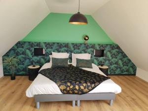 孔卡尔诺La Longère de Marie - Gîtes de Kerblaise的一间卧室设有一张大床和绿色的墙壁