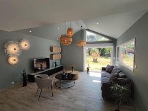 孔卡尔诺La Longère de Marie - Gîtes de Kerblaise的客厅里有一张沙发和一台电视