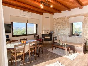 ein Wohnzimmer mit einem Tisch und einem Kamin in der Unterkunft Villa Taf - Kreta in Kamilari
