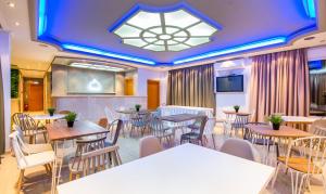 um restaurante com mesas e cadeiras e um lustre em Hotel Discovery Thassos em Limenaria