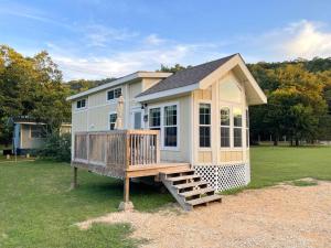 a tiny house with a porch and a deck at Pet friendly Tiny House Rental with new Access to Guadalupe River NBTX in New Braunfels