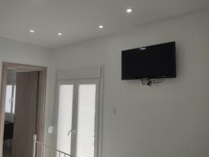 a flat screen tv hanging on a white wall at Las Hermanas for 2 in Perea +7 photos