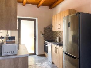 una cocina con nevera de acero inoxidable y armarios de madera en Villa Taf - Kreta, en Kamilari
