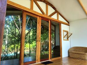 an open pivot door in a house with glass at Kawai Duli Bungalows in El Nido