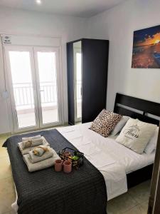 a bedroom with a bed with two towels and two windows at Las Hermanas for 2 in Perea