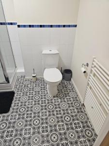 a bathroom with a toilet and a tile floor at Remarkable 2-Bed Apartment in Manchester in Manchester
