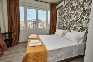 1 dormitorio con 1 cama con 2 toallas en Lycabettus View, en Atenas