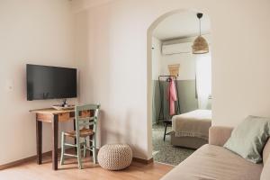 a living room with a desk and a tv on a wall at Stellas Village House in Myrtia