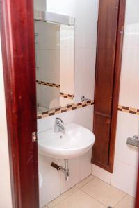 a bathroom with a sink and a mirror at Room in Apartment - This Junior Suite will give a wonderful stay with its great amenities in Kigali