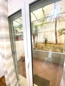 una puerta de cristal con vistas a un patio en Domna Home Next To Sigrou Avenue, en Atenas