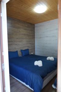 een slaapkamer met een blauw bed met drie handdoeken erop bij Вилно селище "Свети Никола" - язовир Огоста, Монтана - рибари, приятели, гости 0988 продължи 70продължи 9990 in Montana