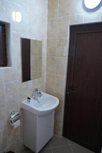 a bathroom with a white sink and a mirror at Вилно селище "Свети Никола" - язовир Огоста, Монтана - рибари, приятели, гости 0988 продължи 70продължи 9990 in Montana