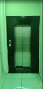 un ascensor de cristal en un baño con suelo de baldosa en Hotel Shree Guest House, en Sawāi Mādhopur