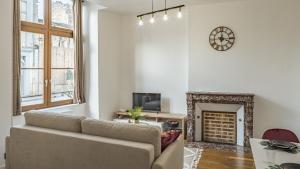 a living room with a couch and a fireplace at Coeur de Bar - Pour Un Séjour Pétillant in Bar-sur-Aube