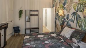 a bedroom with a bed with a floral patterned wall at Coeur de Bar - Pour Un Séjour Pétillant in Bar-sur-Aube
